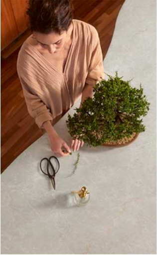 A person arranging greenery on a stone surface