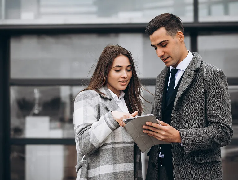 Two business consultants reviewing a tablet