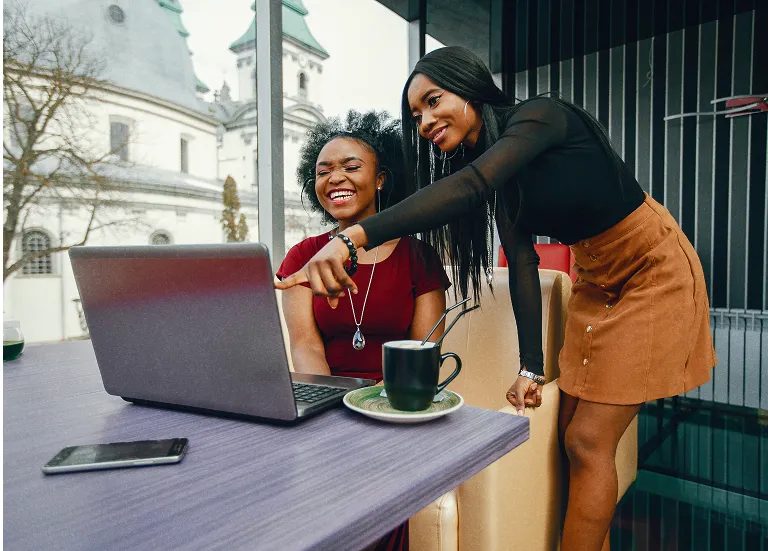 Colleagues collaborating beside a laptop
